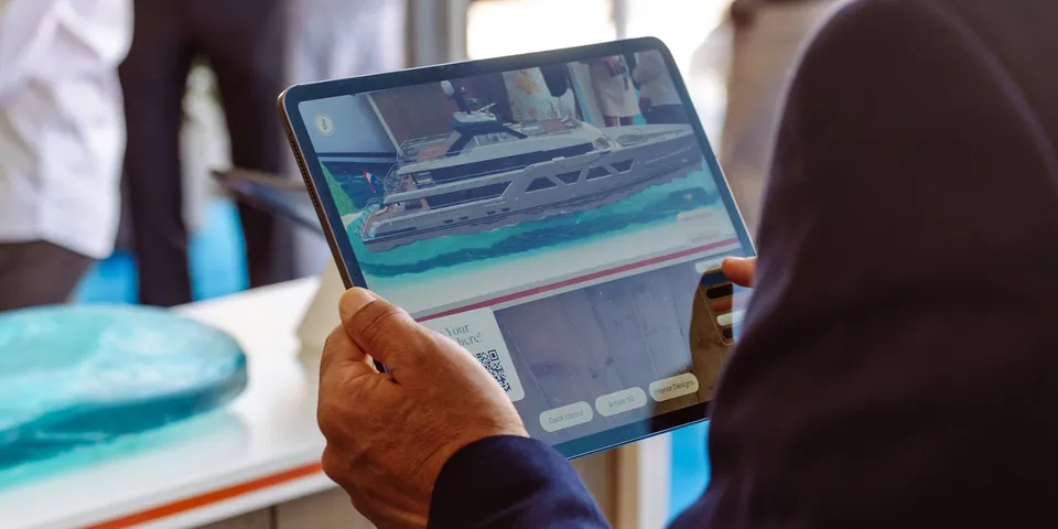 Visitor holding a tablet showing the Damen yacht configurator
