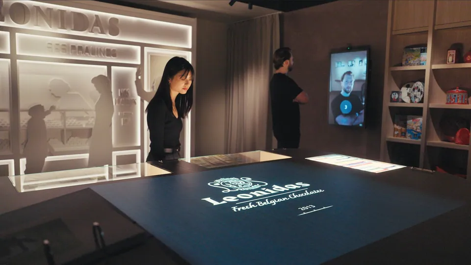 Visitors at the interactive Leonidas table and touchscreen in the experience centre